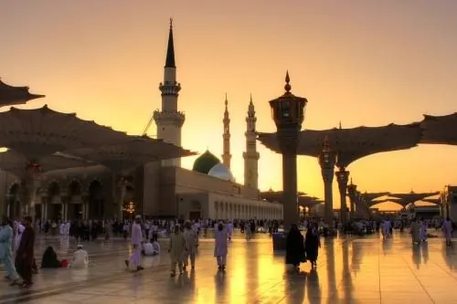 Pilgrims in the courtyard of the Prophet's Mosque at sunset
